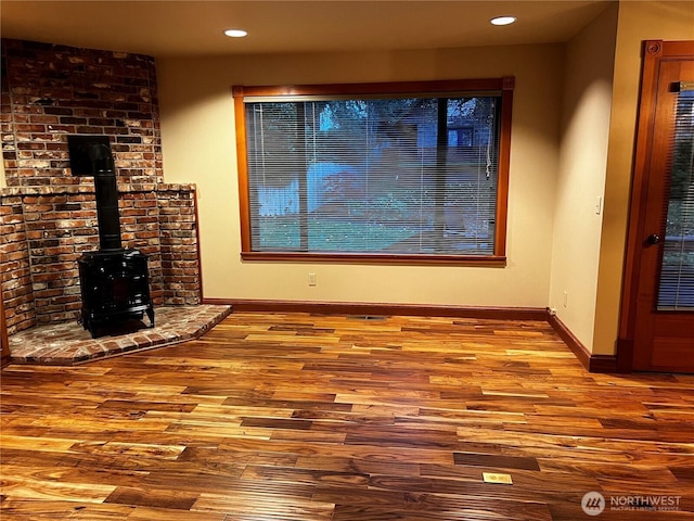 121 4th St, Langley, WA 98260 - unfurnished living room featuring wood finished floors, a wood stove, and recessed lighting