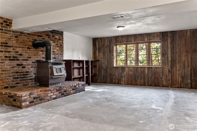 19834 State Route 20, Twisp, WA 98856 - unfurnished living room featuring a wood stove, concrete flooring, and wooden walls