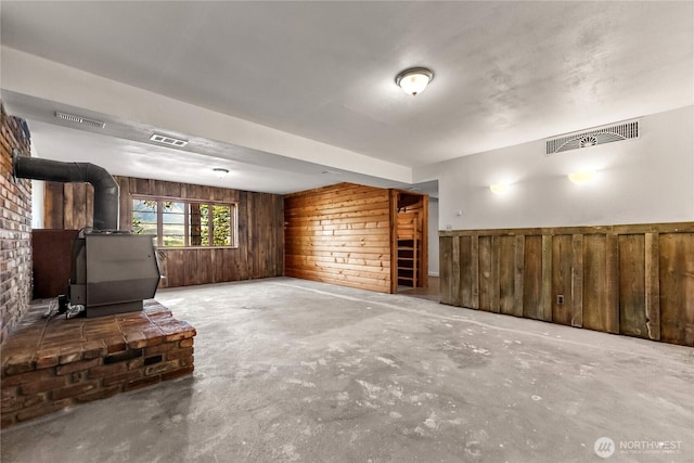 19834 State Route 20, Twisp, WA 98856 - unfurnished living room featuring concrete floors, a wood stove, and wooden walls