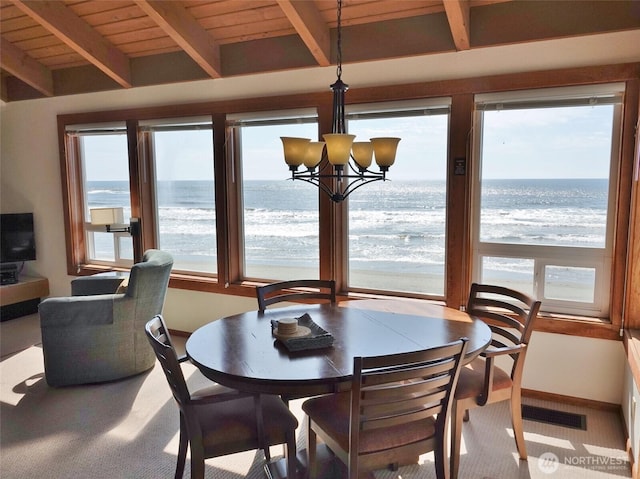 1407 Ocean Shores Blvd SW Unit 3N-H, Ocean Shores, WA 98569 - carpeted dining space featuring a water view, a chandelier, and a wooden ceiling with exposed beams
