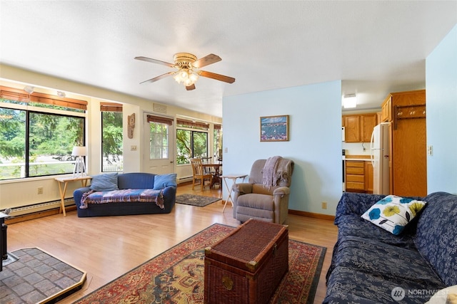 7717 176th Ave SW, Longbranch, WA 98351 - living area with light wood-style flooring, ceiling fan, and a baseboard radiator