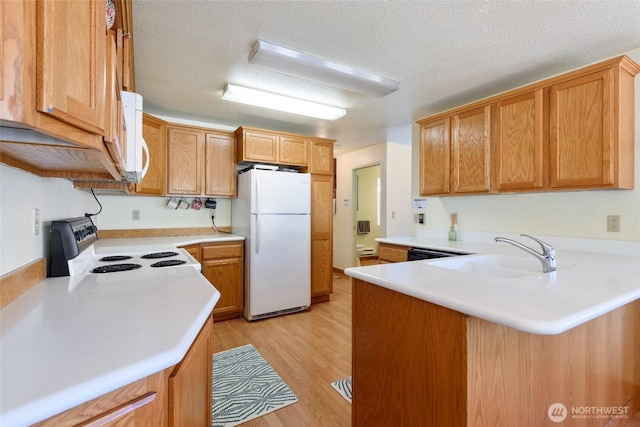 7717 176th Ave SW, Longbranch, WA 98351 - kitchen featuring white appliances, a peninsula, light wood-style floors, light countertops, and a textured ceiling