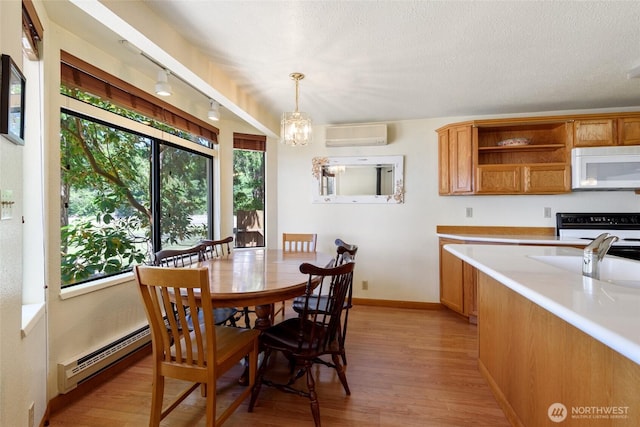 7717 176th Ave SW, Longbranch, WA 98351 - dining area featuring a wall mounted AC, light wood-style floors, and a chandelier