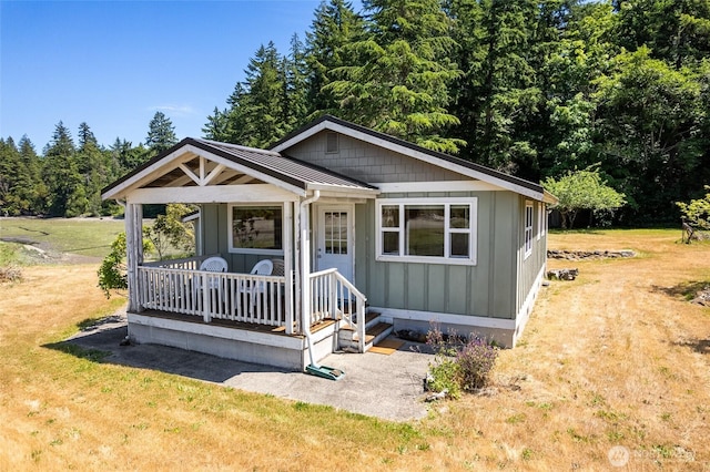 7717 176th Ave SW, Longbranch, WA 98351 - view of front of house with a front yard, a standing seam roof, a metal roof, and board and batten siding