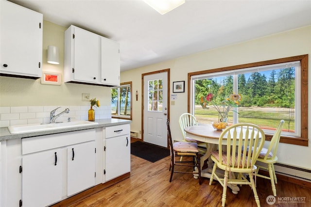 7717 176th Ave SW, Longbranch, WA 98351 - kitchen featuring light wood-type flooring, tasteful backsplash, light countertops, and white cabinets