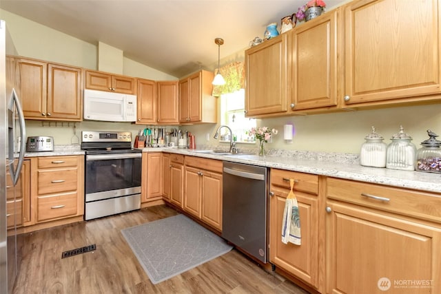 2101 S 324th St Unit 22, Federal Way, WA 98003 - kitchen featuring appliances with stainless steel finishes, vaulted ceiling, light wood-type flooring, light brown cabinets, and hanging light fixtures