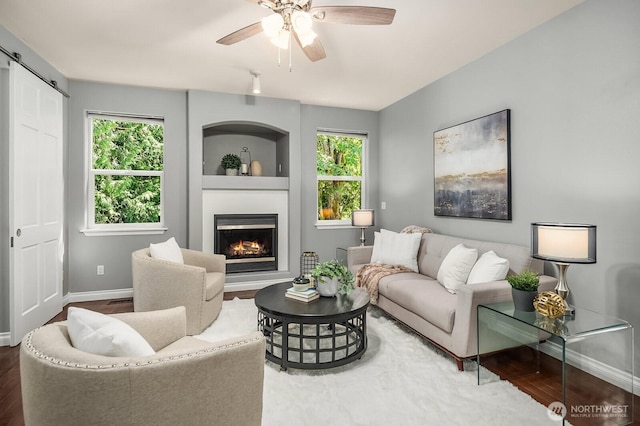 10113 SE 220th Pl, Kent, WA 98031 - living room featuring a large fireplace, a ceiling fan, healthy amount of natural light, and wood finished floors