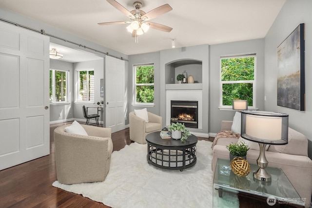 10113 SE 220th Pl, Kent, WA 98031 - living area featuring a barn door, wood finished floors, a ceiling fan, and a glass covered fireplace