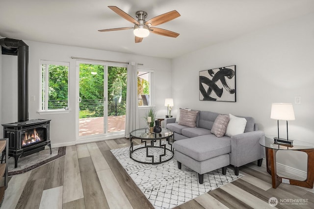 10113 SE 220th Pl, Kent, WA 98031 - living room featuring a wood stove, a ceiling fan, and light wood-style flooring