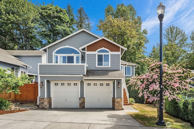 10113 SE 220th Pl, Kent, WA 98031 - view of front facade with concrete driveway, stone siding, a garage, and stairway