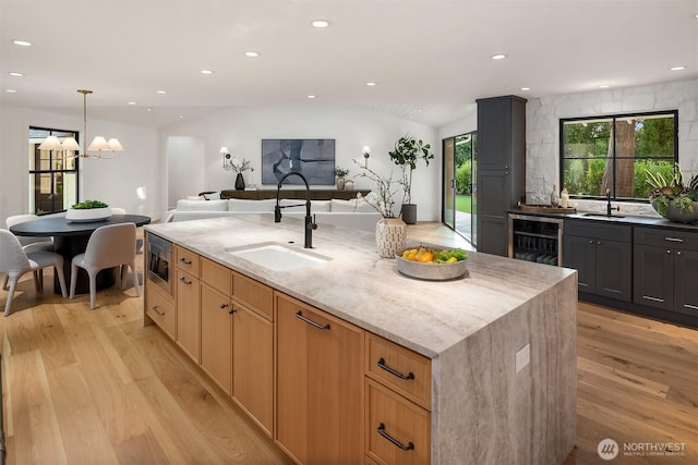 2610 86th Ave NE, Clyde Hill, WA 98004 - kitchen with beverage cooler, light wood-style floors, stainless steel microwave, light stone counters, and recessed lighting