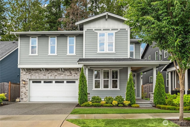 3052 SE 13th Pl, North Bend, WA 98045 - view of front of house with driveway, stone siding, a garage, and covered porch