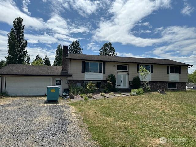 129 W Washington St, Napavine, WA 98565 - view of front of home with gravel driveway, a garage, a front yard, and a chimney