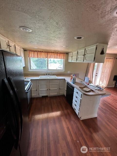 129 W Washington St, Napavine, WA 98565 - kitchen with black appliances, a textured ceiling, dark wood-style floors, light countertops, and white cabinets