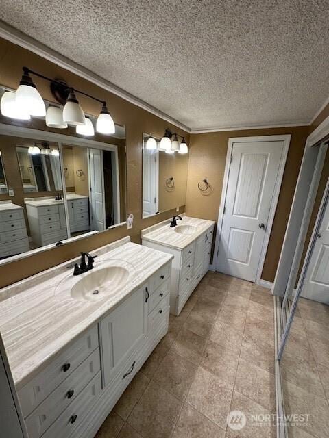 129 W Washington St, Napavine, WA 98565 - bathroom with crown molding, two vanities, a textured ceiling, and tile patterned floors