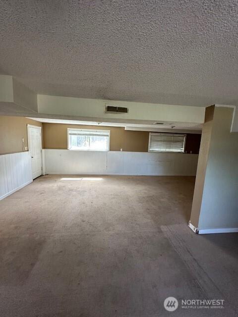 129 W Washington St, Napavine, WA 98565 - carpeted spare room featuring a textured ceiling and a wainscoted wall