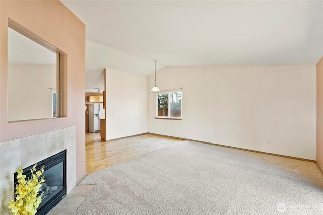 8506 8th Ct SE, Olympia, WA 98513 - unfurnished living room featuring lofted ceiling, light colored carpet, and a tiled fireplace