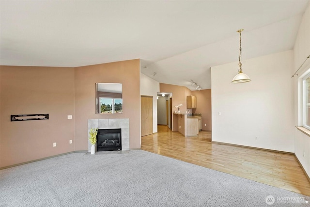 8506 8th Ct SE, Olympia, WA 98513 - unfurnished living room with carpet, lofted ceiling, a fireplace, and healthy amount of natural light