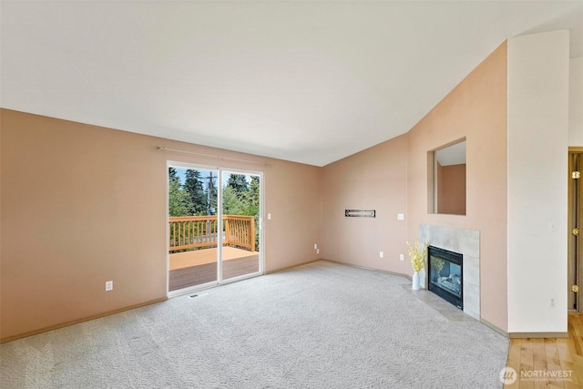 8506 8th Ct SE, Olympia, WA 98513 - unfurnished living room with vaulted ceiling, a tiled fireplace, and light carpet