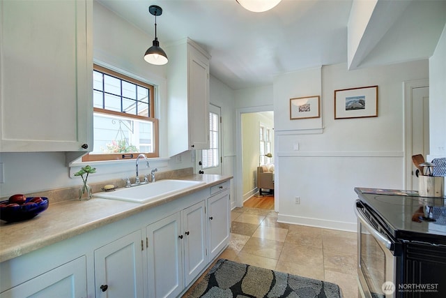 752 N 84th, Seattle, WA 98103 - kitchen with stainless steel range with electric stovetop, light countertops, white cabinetry, and pendant lighting