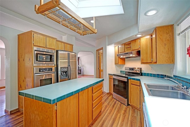 832 Margie Ann Dr, Camano Island, WA 98282 - kitchen with appliances with stainless steel finishes, arched walkways, under cabinet range hood, light wood-style floors, and recessed lighting
