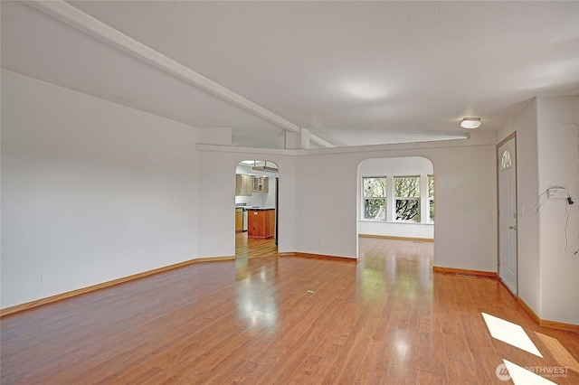 832 Margie Ann Dr, Camano Island, WA 98282 - unfurnished living room with arched walkways and light wood-style flooring