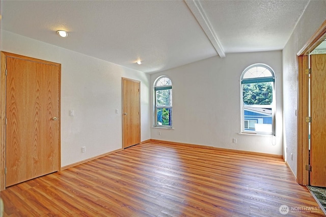 832 Margie Ann Dr, Camano Island, WA 98282 - unfurnished bedroom with wood finished floors, multiple windows, and a textured ceiling