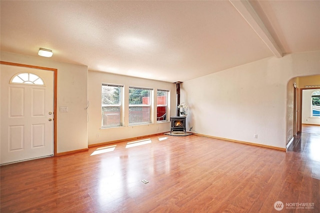 832 Margie Ann Dr, Camano Island, WA 98282 - unfurnished living room with a wood stove, wood finished floors, and arched walkways