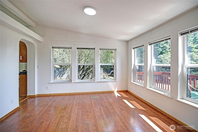 832 Margie Ann Dr, Camano Island, WA 98282 - spare room featuring arched walkways, healthy amount of natural light, wood finished floors, and lofted ceiling