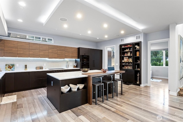 3108 92nd Ave NE, Clyde Hill, WA 98004 - kitchen with a breakfast bar area, light wood-style floors, modern cabinets, a center island, and black electric cooktop
