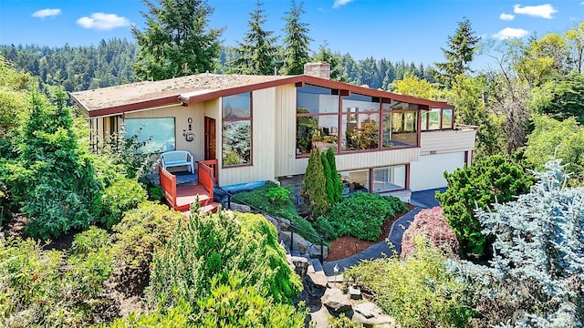 16906 13th Ave NW, Shoreline, WA 98177 - view of front facade with a chimney, a sunroom, and a wooded view