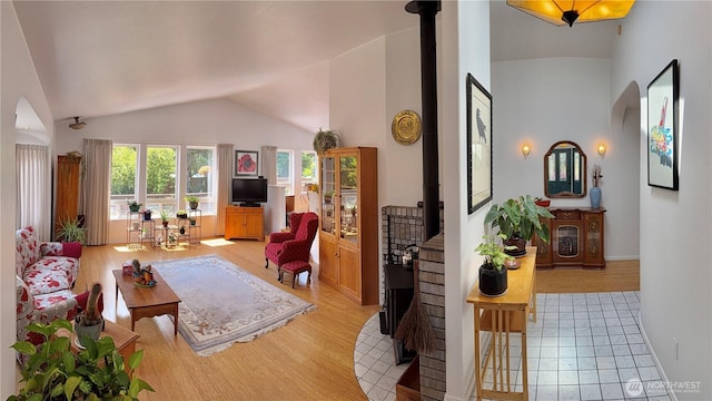 10 Davenhill Ln, Sequim, WA 98382 - living room featuring light wood-style floors, arched walkways, a wood stove, and high vaulted ceiling
