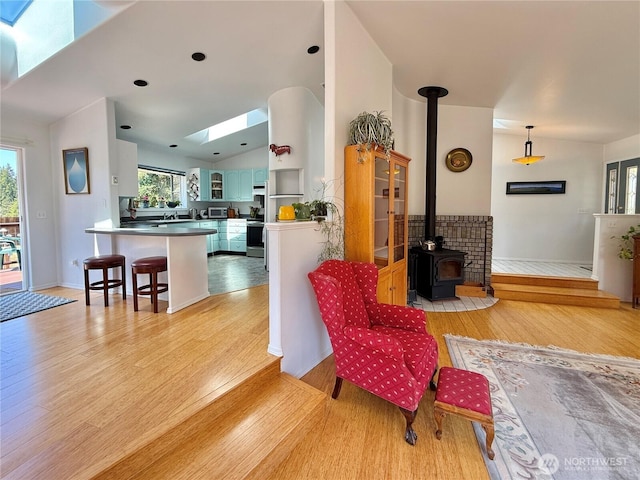 10 Davenhill Ln, Sequim, WA 98382 - living room featuring a skylight, light wood finished floors, lofted ceiling, and a wood stove