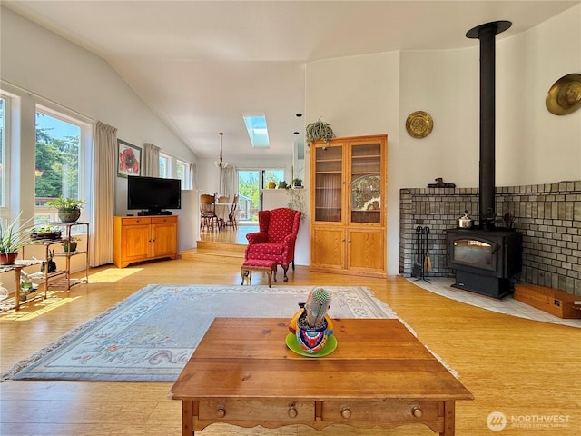 10 Davenhill Ln, Sequim, WA 98382 - living area featuring a wood stove, light wood-style flooring, vaulted ceiling, and a skylight
