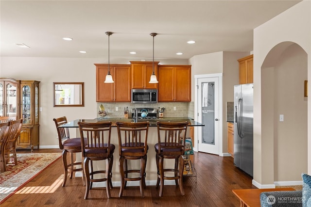 5539 Charlotte Ave SE, Auburn, WA 98092 - kitchen featuring appliances with stainless steel finishes, tasteful backsplash, a kitchen breakfast bar, dark wood-style flooring, and recessed lighting