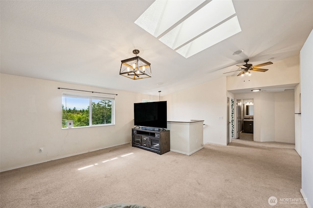 210 E Mossflower Ln, Grapeview, WA 98546 - unfurnished living room featuring a skylight, carpet floors, vaulted ceiling, ceiling fan, and a chandelier