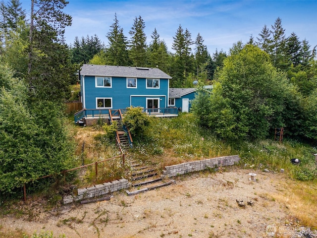 210 E Mossflower Ln, Grapeview, WA 98546 - view of front of property featuring a wooden deck, stairs, and a wooded view