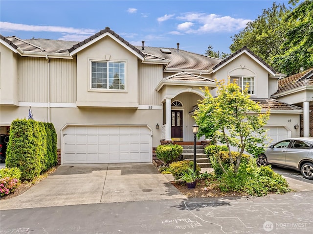 8221 53rd Ave W Unit 15C, Mukilteo, WA 98275 - view of front of house featuring a garage, concrete driveway, and stucco siding