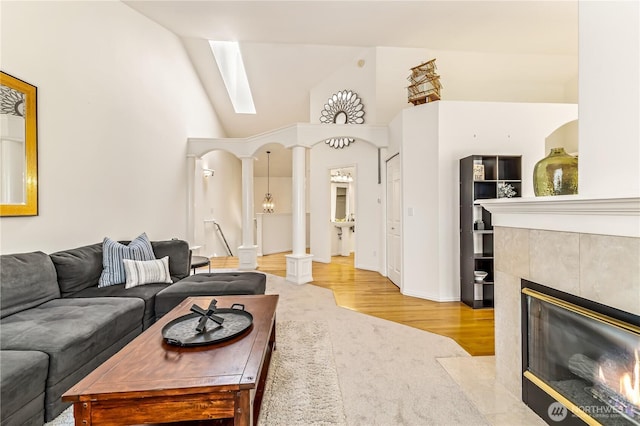 8221 53rd Ave W Unit 15C, Mukilteo, WA 98275 - carpeted living room with wood finished floors, a tiled fireplace, a skylight, and high vaulted ceiling