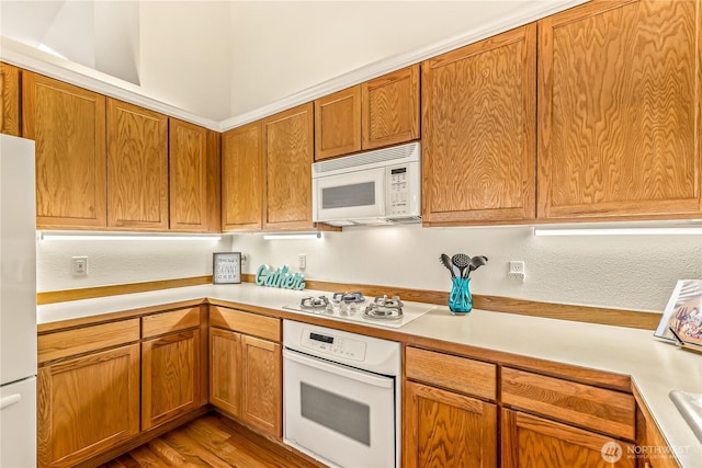 8221 53rd Ave W Unit 15C, Mukilteo, WA 98275 - kitchen featuring white appliances, light countertops, and wood finished floors