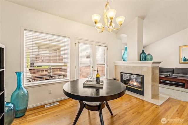 8221 53rd Ave W Unit 15C, Mukilteo, WA 98275 - dining area with wood finished floors, a chandelier, and a tiled fireplace