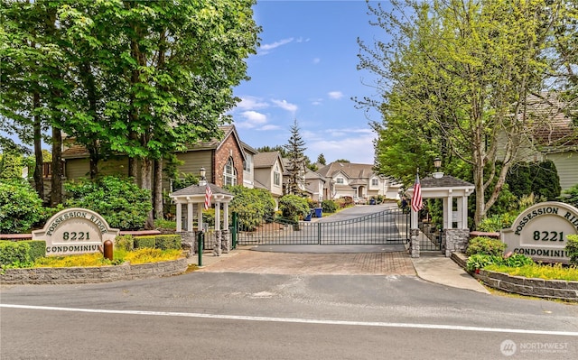 8221 53rd Ave W Unit 15C, Mukilteo, WA 98275 - view of asphalt street featuring a gate, a residential view, street lighting, and a gated entry