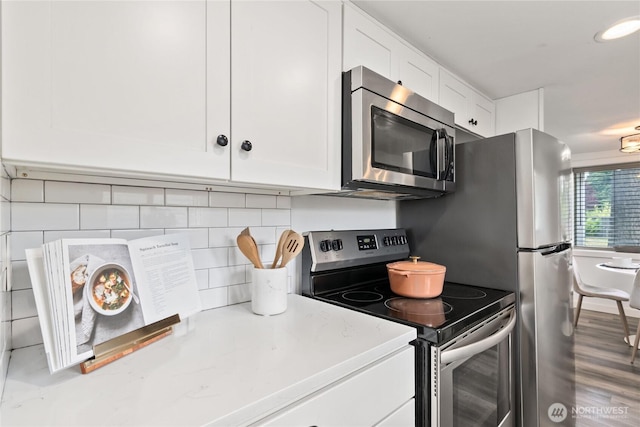 1902 72nd St E, Tacoma, WA 98404 - kitchen with appliances with stainless steel finishes, white cabinets, and backsplash