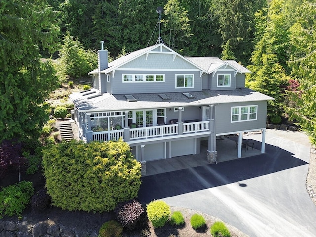453 Louella Heights Dr, Sequim, WA 98382 - view of front of property with driveway, a chimney, a view of trees, and an attached garage