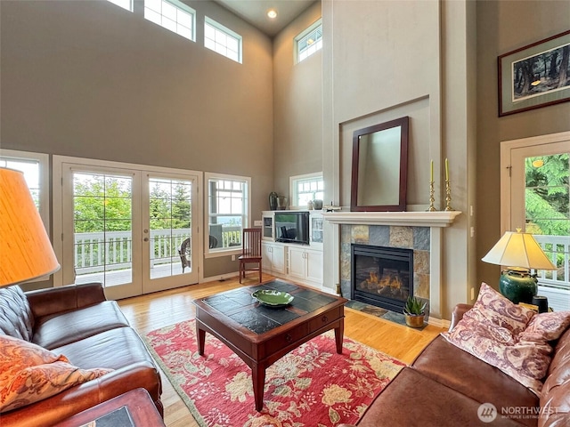 453 Louella Heights Dr, Sequim, WA 98382 - living area featuring a high ceiling, a tile fireplace, wood finished floors, and french doors