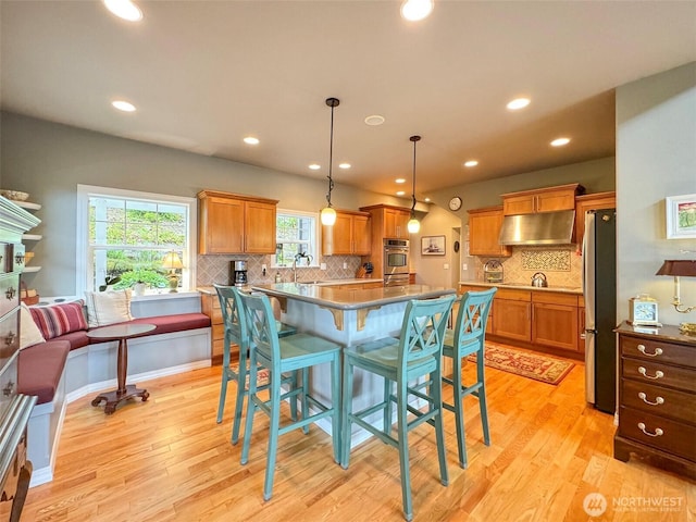 453 Louella Heights Dr, Sequim, WA 98382 - kitchen with range hood, stainless steel appliances, light wood-style flooring, decorative backsplash, and recessed lighting