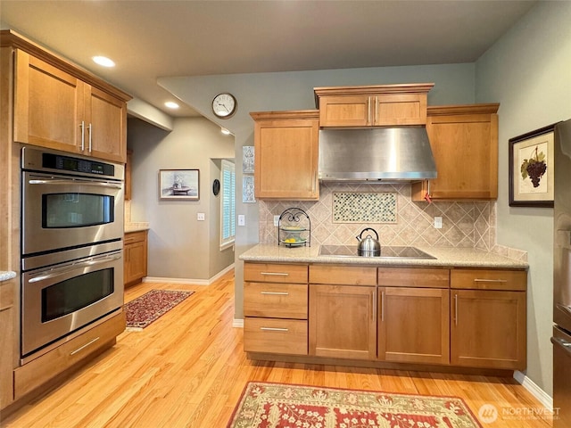 453 Louella Heights Dr, Sequim, WA 98382 - kitchen with wall chimney exhaust hood, double oven, light wood-style flooring, tasteful backsplash, and recessed lighting