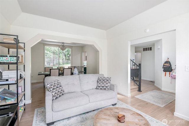 11011 203rd Ave E, Bonney Lake, WA 98391 - living room featuring wood finished floors, arched walkways, and stairs