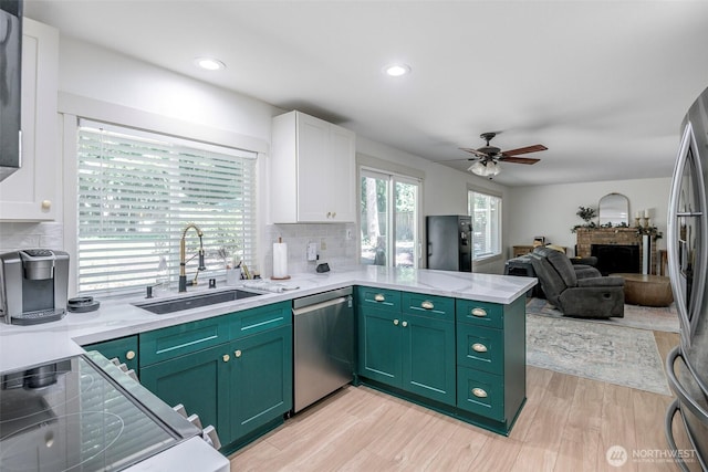 11011 203rd Ave E, Bonney Lake, WA 98391 - kitchen with appliances with stainless steel finishes, green cabinets, white cabinets, a brick fireplace, and recessed lighting