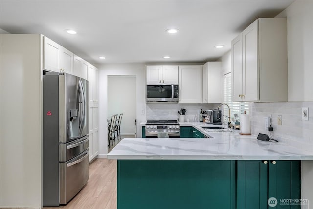 11011 203rd Ave E, Bonney Lake, WA 98391 - kitchen with appliances with stainless steel finishes, a peninsula, light wood-style flooring, light stone countertops, and decorative backsplash
